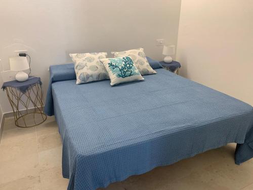 a blue bed with two pillows on top of it at Smeralda APARTMENT in Cannigione