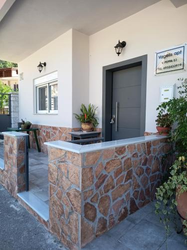 a stone retaining wall with a door on a house at Vagelis Nemea apartments in Neméa
