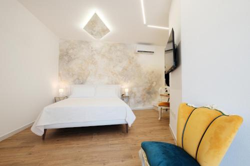 a bedroom with a white bed and a couch at Luxury l'Aurora Room in Castelsardo