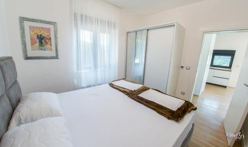 a bedroom with a white bed with a towel on it at Villa Panorama Olive Hill in Mostar