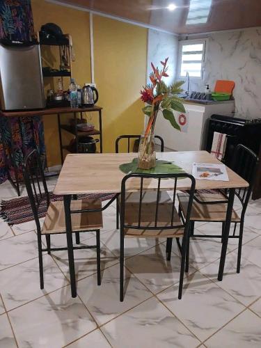 a table and chairs with a vase of flowers on it at Tereva home in Bora Bora