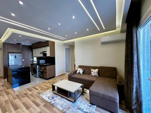 a living room with a couch and a kitchen at Modern Apartment in Madinaty