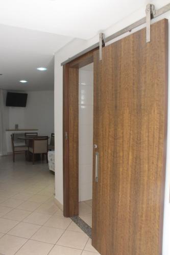a wooden door in a room with a table at Actuall Convention by Summit Hotels in Contagem
