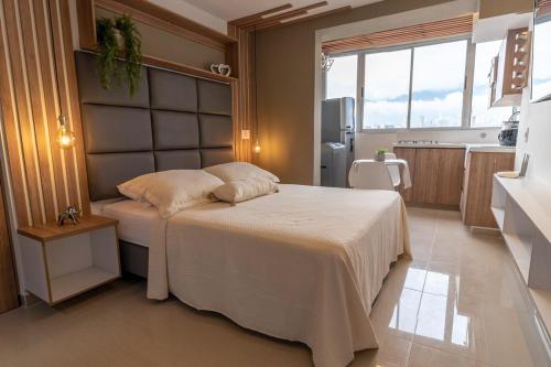 a bedroom with a bed and a kitchen at Apartasuite Stay & Relax Itagui in Itagüí