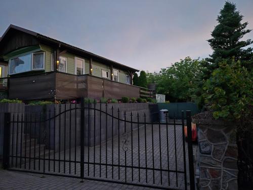 a house with a black fence in front of it at Juno Holiday in Mrągowo