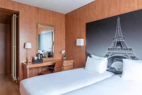 a bedroom with a bed with a eiffel tower mural at Best Western Ronceray Opéra in Paris