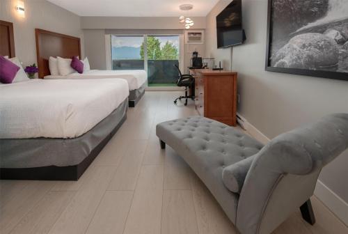 a hotel room with two beds and a couch at Coast Metro Vancouver Hotel in Burnaby