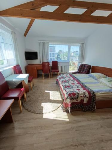 a bedroom with a bed and a table and chairs at Bursztyn in Rewal