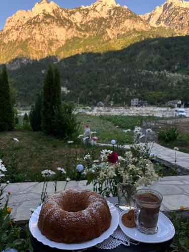 a cake on a table with a view of a mountain at Bujtina Brahim Selimaj in Valbonë