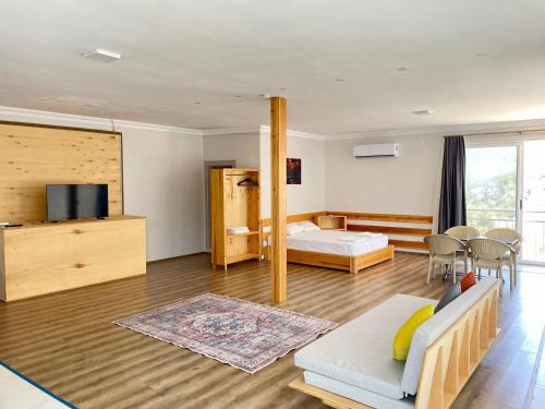 a bedroom with a bed and a living room at GREEN HiLL DEFNE APART in Kaş