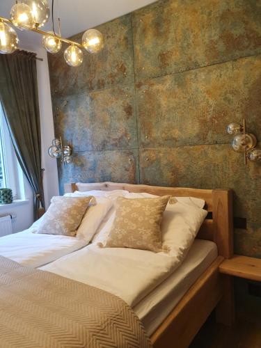 een slaapkamer met twee bedden en een bakstenen muur bij Apartament Łynova z parkingiem podziemnym in Olsztyn