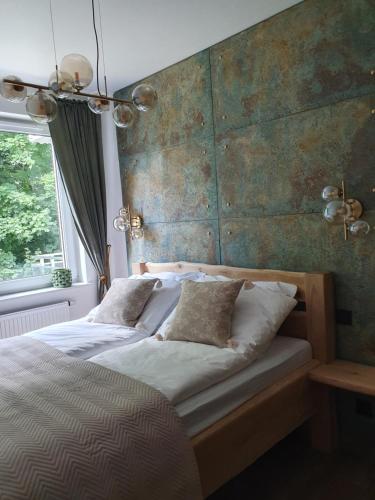 a bedroom with a large bed with a wooden headboard at Apartament Łynova z parkingiem podziemnym in Olsztyn