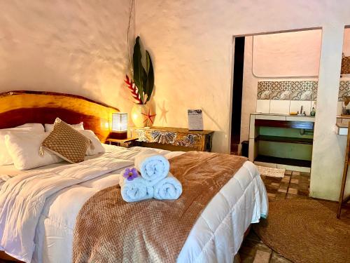 a bedroom with a bed with a teddy bear on it at Kika Zaru Free park tour, massage and breakfast in Quepos