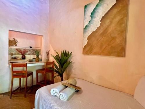 a room with a bed with a table and a kitchen at Kika Zaru Free park tour, massage and breakfast in Quepos