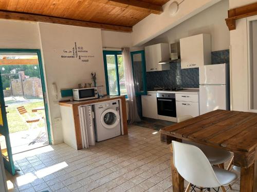 Una cocina con lavadora y una mesa de madera. en Casa Mia, en Villamassargia