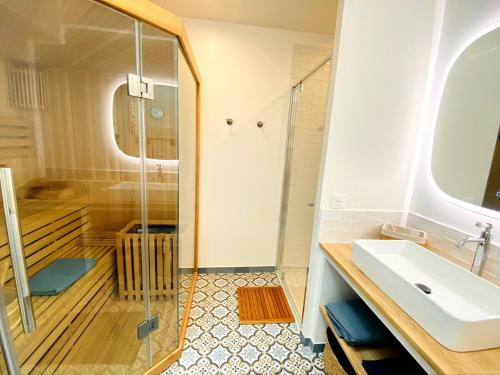 a bathroom with a shower and a sink at Nature luxuriante, jeux en famille, workation et Sauna pour 1 à 4 personnes in Labosse
