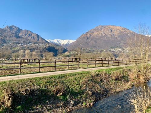 a bridge over a river with mountains in the background at Old Porlezza Apartment in Porlezza
