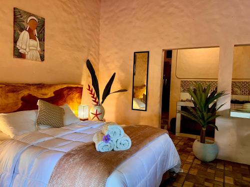 a bedroom with a bed with two towels on it at Kika Zaru Free park tour, massage and breakfast in Quepos