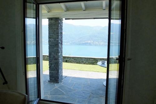 a room with a view of the water through a glass door at Casa Panorama in Brissago