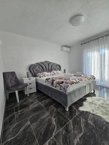 a bedroom with a large bed and a chair at Deluxe House Aqua Una in Otoka