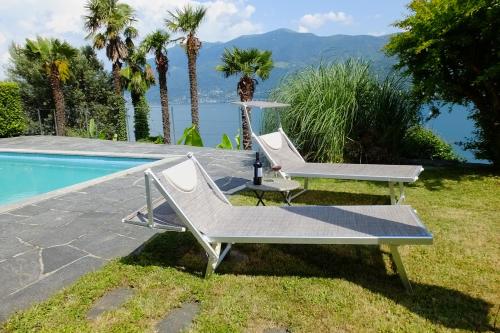 a pair of chairs and a table next to a pool at Casa Panorama in Brissago
