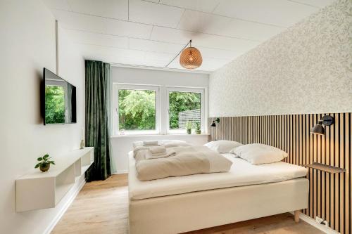 a white bedroom with a large bed in a room at Billund HomeStay in Billund