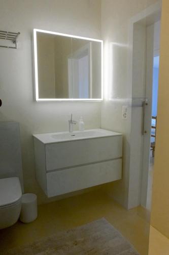 a white bathroom with a sink and a mirror at Casa Panorama in Brissago