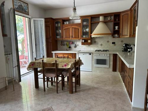 a kitchen with a table with chairs and a kitchen with at Apartment by the sea in Ventimiglia