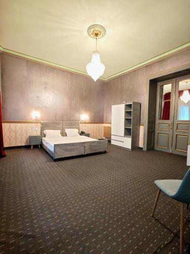 a large bedroom with a bed and a refrigerator at Nostalgia Old City Bucharest in Bucharest