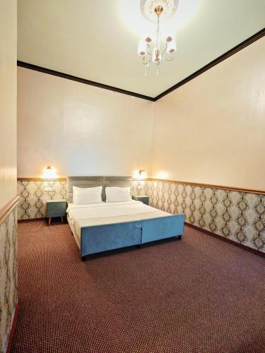 a large bedroom with a bed and a chandelier at Nostalgia Old City Bucharest in Bucharest