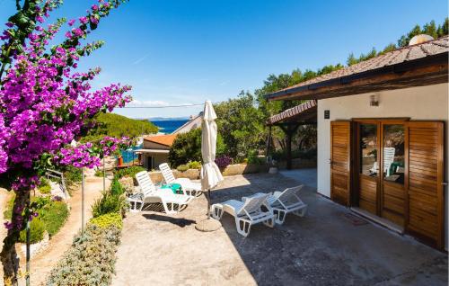 un patio con sillas y una sombrilla junto a un edificio en Lovely Home In Hvar With Wifi, en Hvar