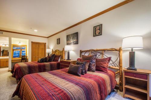 a bedroom with two beds and a lamp at Downtown 2 Bedroom Town Lift in Park City