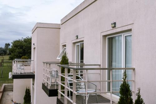 a balcony with chairs and tables on a building at Altos de Tandil Hotel Boutique & Spa in Tandil