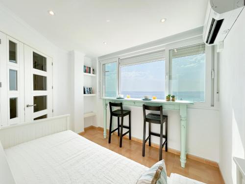 a small kitchen with a table and two stools at Modern appartment with sea views in Sabinillas in San Luis de Sabinillas