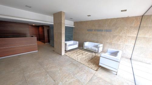a bathroom with two white chairs and a sink at 3375 Home - A pasos de Montevideo Shopping, la playa y WTC in Montevideo
