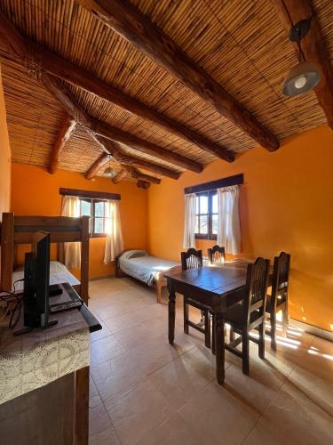 a living room with a table and chairs and a bed at Departamentos Complejo Turístico Cruz Mendoza in Tilcara