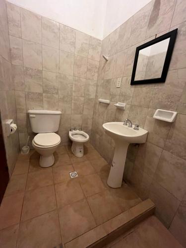 a bathroom with a toilet and a sink at Departamentos Complejo Turístico Cruz Mendoza in Tilcara