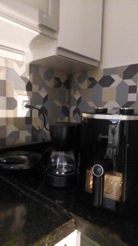a kitchen counter top with a pot on a stove at Apartment with outdoor area, cozy in Campos dos Goytacazes