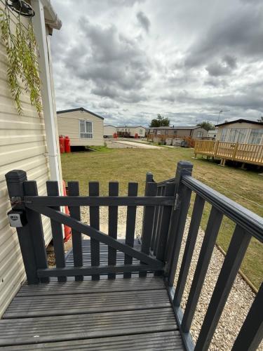 a wooden deck with a fence on the side of a house at Andreas Fir Trees Retreat at 7 Lakes Country Park in Crowle