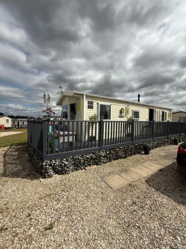 a small house with a fence in front of it at Andreas Fir Trees Retreat at 7 Lakes Country Park in Crowle
