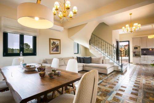 a living room with a table and a couch at Pleiades Luxury Villa in Svoronata