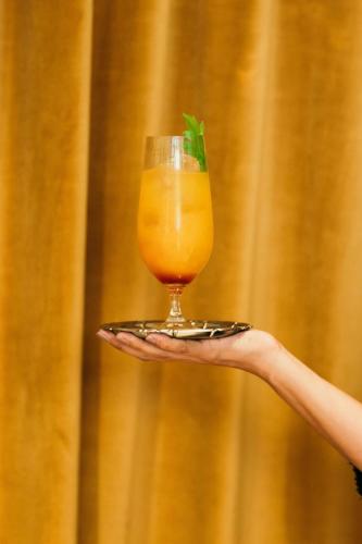 a hand holding a glass of orange juice at Renaissance Paris Vendome Hotel in Paris
