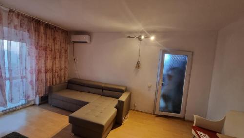 ein Wohnzimmer mit einer Couch und einem Fenster in der Unterkunft Garsoniera spațioasă in Constanţa