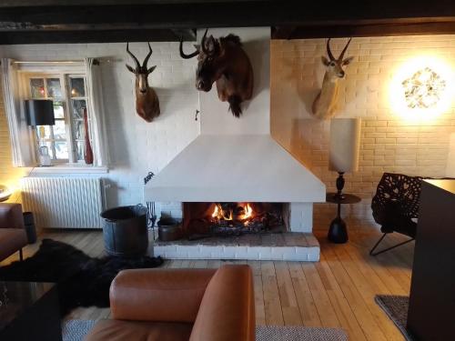 a living room with a fireplace withanimal heads on the wall at Hotel Strandvejen in Fanø