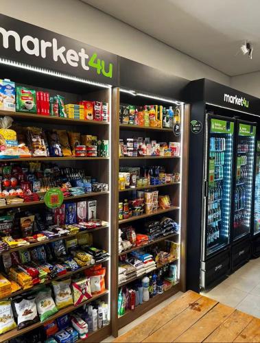 a grocery store with a refrigerator and shelves of food at Trink Home in Sao Paulo