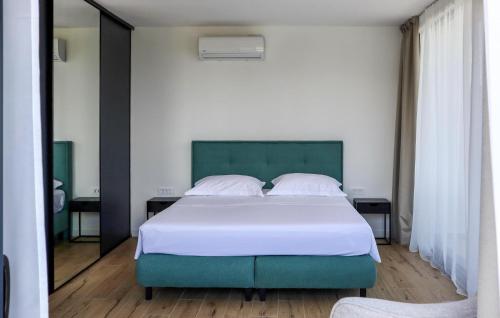 a bedroom with a large bed and a mirror at Cozy Home In Rogac With Sauna in Rogač