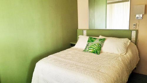 a bedroom with a bed with a green wall at Green Sea Suite at High Point North in Ocean City