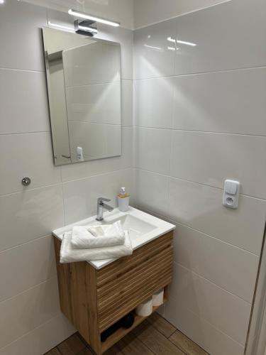 a white bathroom with a sink and a mirror at Apartmán 7 - Petřín in Karlovy Vary