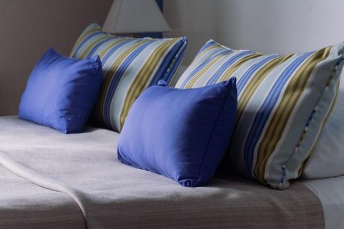 a couch with three blue pillows on it at Altos de Tandil Hotel Boutique & Spa in Tandil