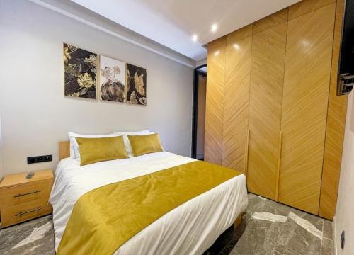 a bedroom with a large bed and a wooden cabinet at Luxury Modern Studio with Netflix, Kitchen and Free Parking Elite Garden, Marrakesh in Aït Saïd